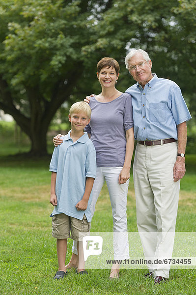 Three generation family standing in park