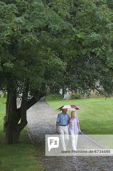 Seniorenpaar geht in Park spazieren