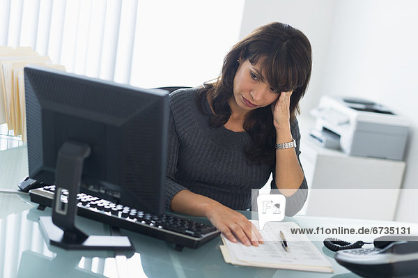 Business woman using computer  looking tired