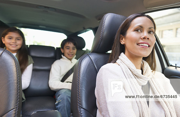 Mother with son (12-13) and daughter (10-11) in car