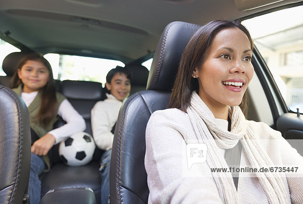 Mother with son (12-13) and daughter (10-11) in car