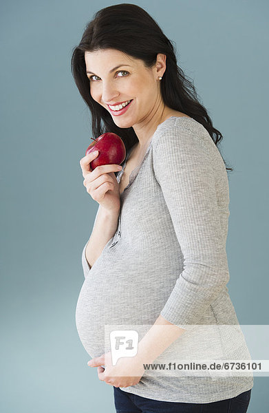 Portrait  Frau  Schwangerschaft  Apfel  Studioaufnahme  essen  essend  isst