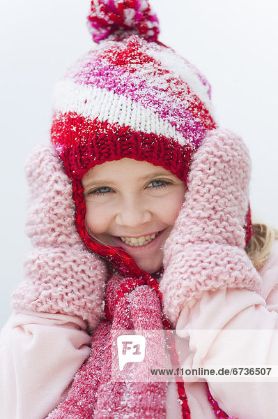 Portrait of smiling girl (8-9) wearing winter clothing