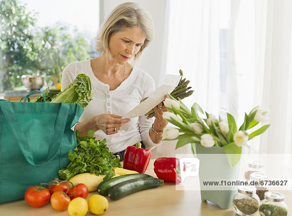 Portrait of senior woman with shopping bag in kitchen