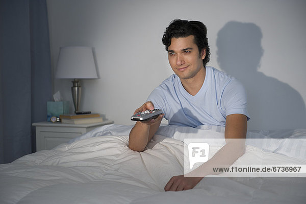 Man watching tv in bed