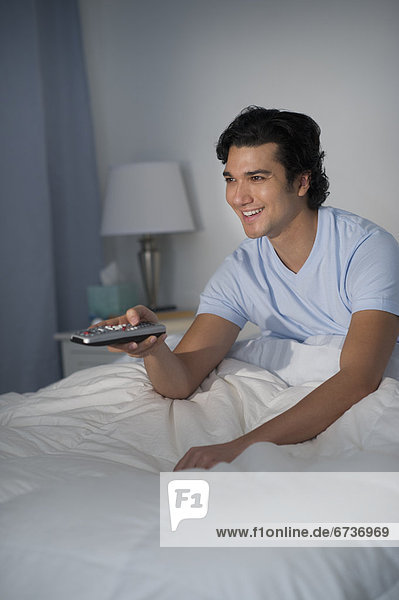 Man watching tv in bed
