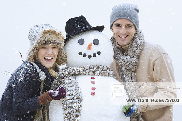 Portrait of couple with snowman