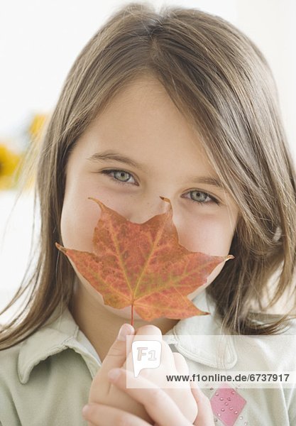 Mädchen hält Herbst Leaf Gesicht