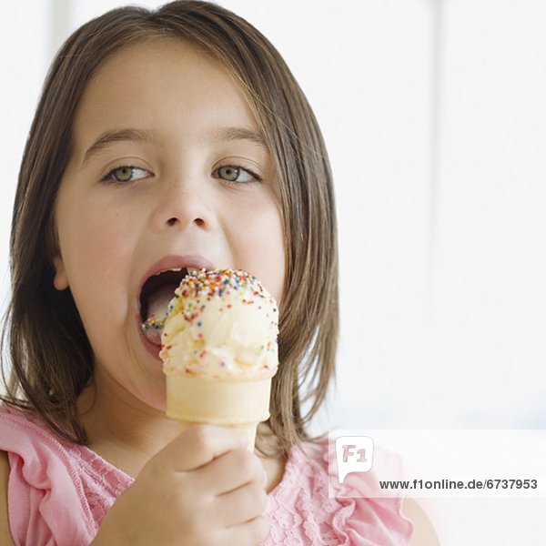 kegelförmig  Kegel  hoch  oben  nahe  Eis  essen  essend  isst  Mädchen  Sahne