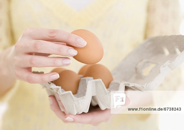 Woman holding carton of eggs