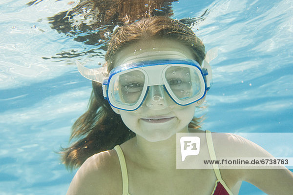 Girl with goggles swimming underwater