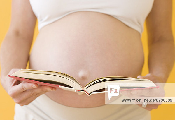 Frau  Buch  offen  halten  Schwangerschaft  Taschenbuch