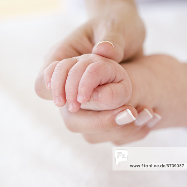 Close up of mother holding babyÕs hand