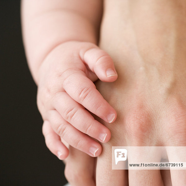 Close up of baby touching motherÕs hand
