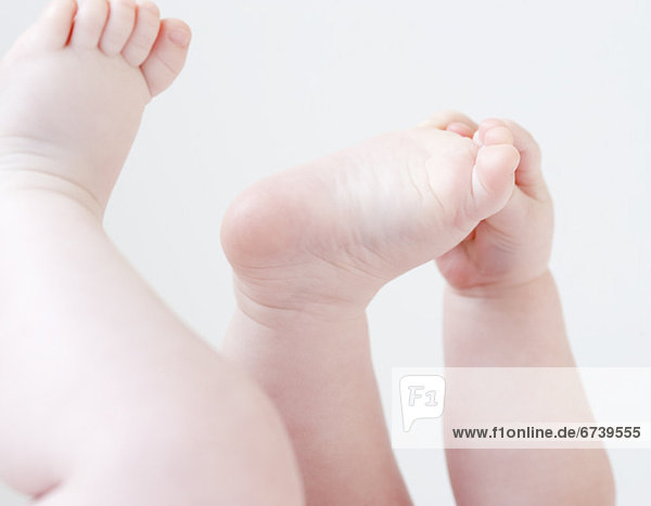 Close up of baby grabbing feet
