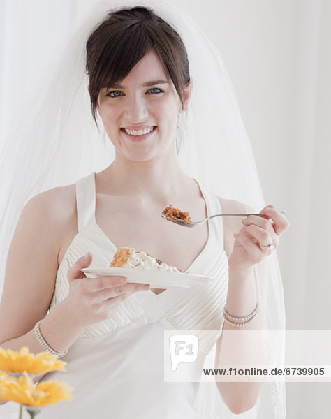 Portrait of bride eating wedding cake