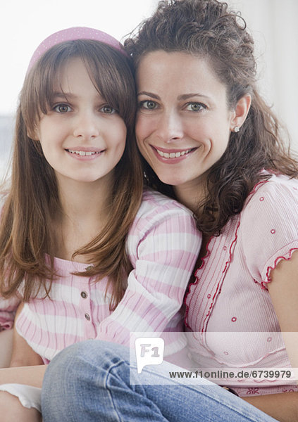 Mother and daughter (10-12 years) embracing  smiling  portrait