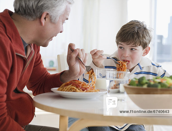 Father and son eating spaghetti