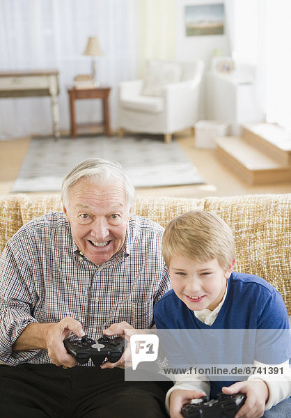 Grandfather and grandson (8-9) playing video games