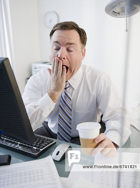 USA  Jersey City  New Jersey  businessman yawning in office
