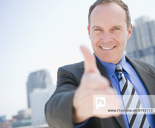 USA  New Jersey  Jersey City  Businessman showing thumbs up