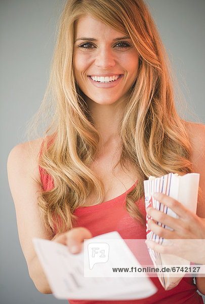 Portrait of blonde woman showing tickets
