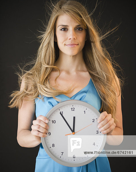 Portrait of woman holding clock