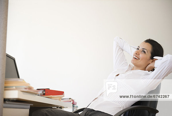 Businesswoman relaxing at desk in office