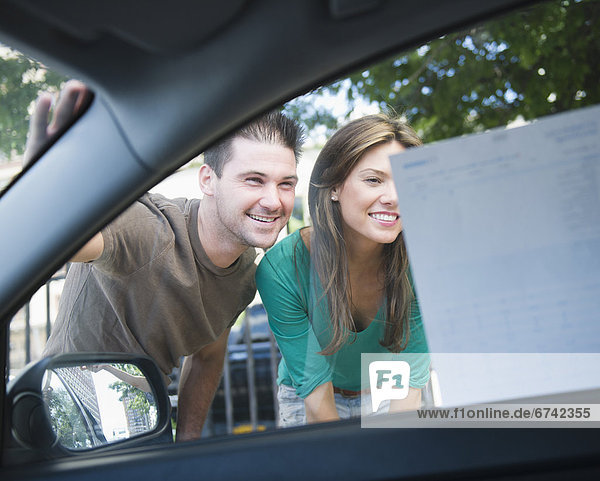 Smiling couple riding advertisement on car window