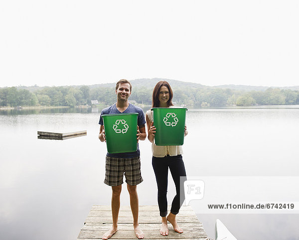 USA  New York  Putnam Valley  Roaring Brook Lake  Couple standing on pier with recycling bins