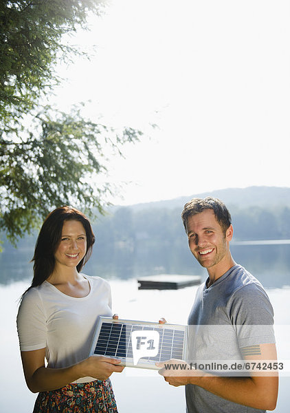 Roaring Brook Lake  Couple holding solar panel