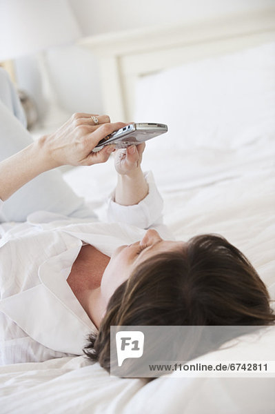 Woman using pda on bed