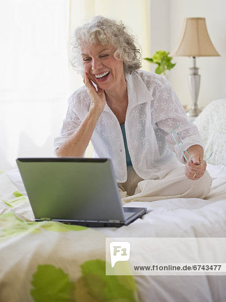 Cheerful woman looking at laptop