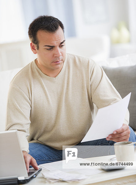 Portrait of man doing paperwork in living room