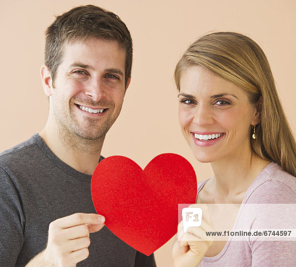 Couple holding red paper heart