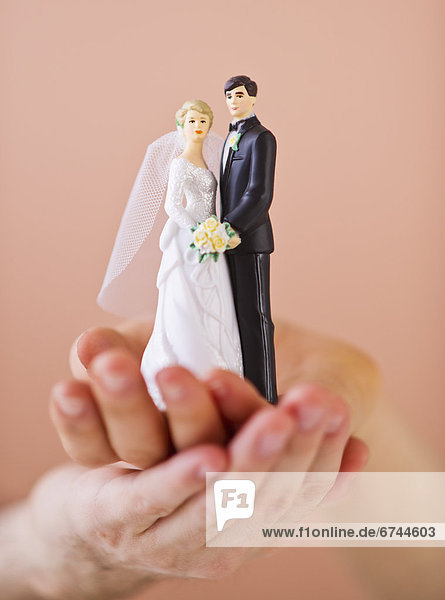 Couple holding small wedding figurine
