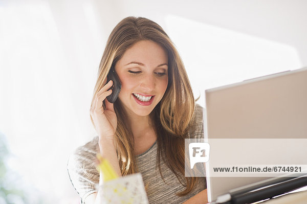 Portrait of young woman working with laptop and mobile phone