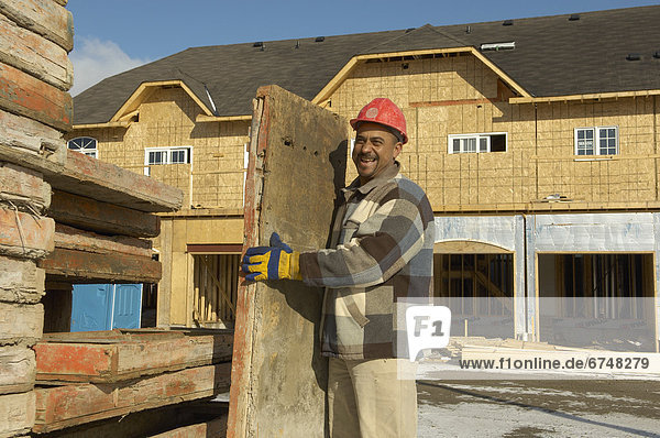 Construction Worker holding Wood Platform at New Housing Development  Ajax  Ontario