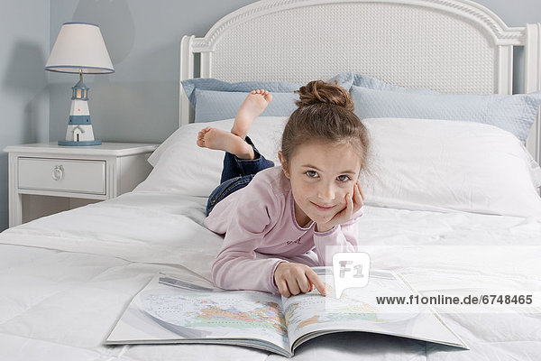 Young Girl Laying on Bed Reading Book  Toronto  Ontario