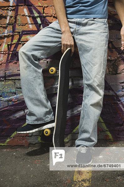 Mann  Wand  halten  Skateboard  frontal
