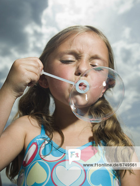 Young girl blowing bubble
