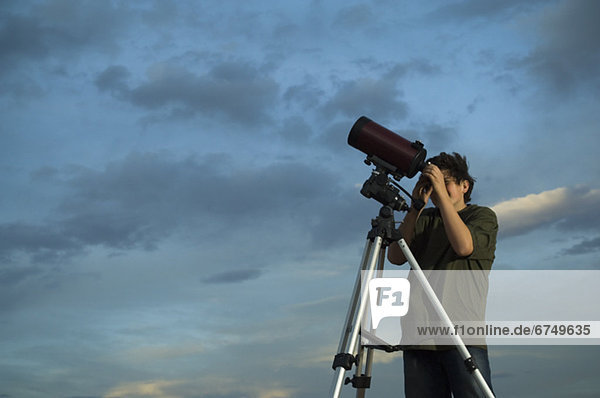 Man using telescope on tripod