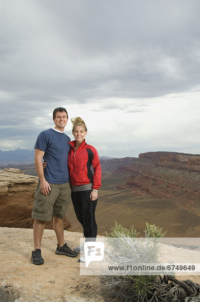 Couple standing at edge of cliff