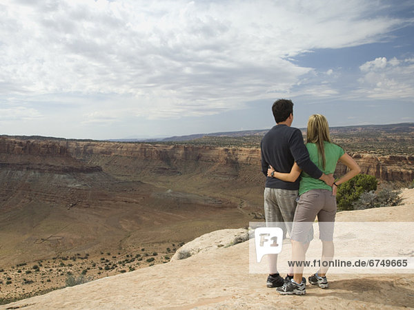 Couple looking over edge of cliff
