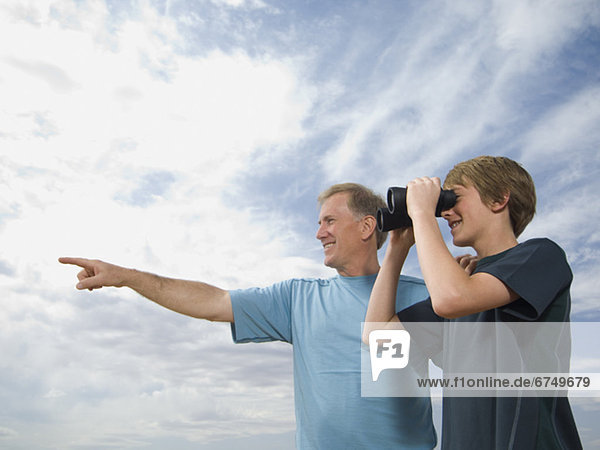 Father and son using binoculars