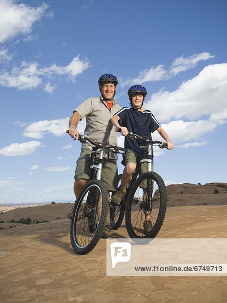 Portrait of father and son on mountain bikes