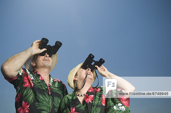 Senior couple looking through binoculars