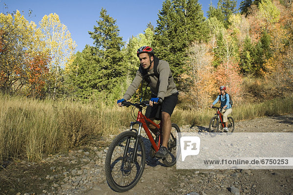 Couple riding mountain bikes  Utah  United States
