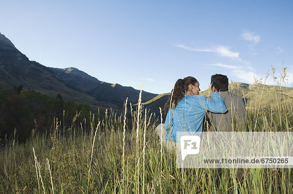 Couple sitting on hillside  Utah  United States