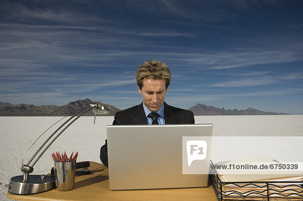 Businessman on salt flats looking at laptop  Salt Flats  Utah  United States